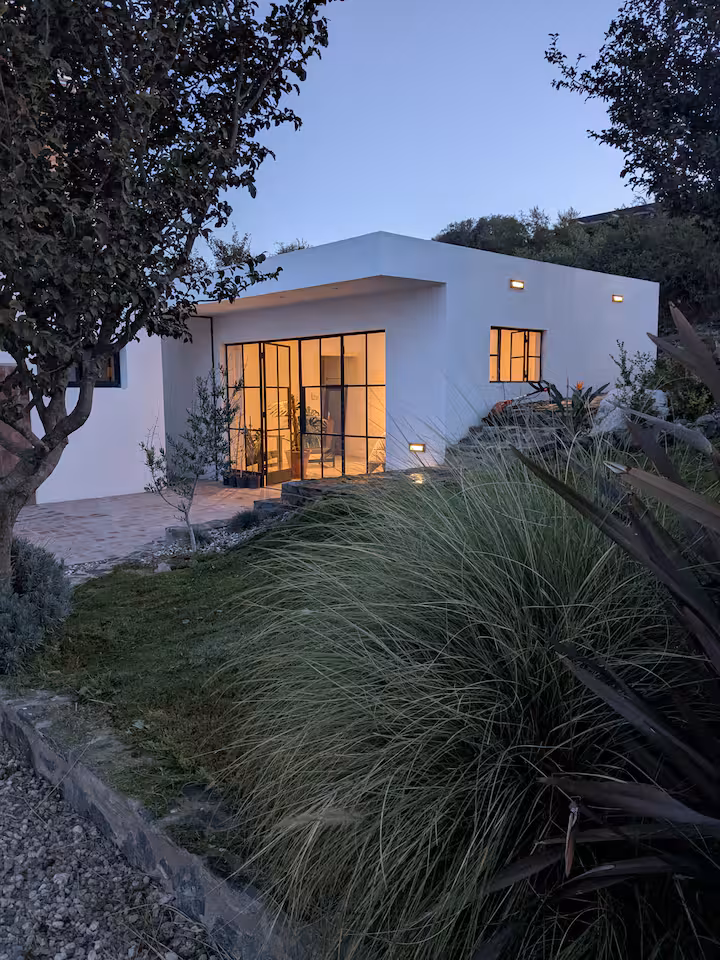 House at dusk — glowing steel-frame windows